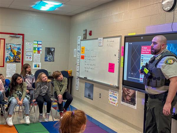 police officer talking to class of students